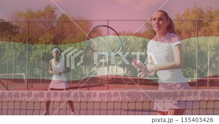 Pink skirt player returning ball on clay court with rackets, net and chain-link fence, copy space 135403426