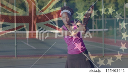 Swinging female tennis player hitting backhand on court with net, British flag and EU stars overlay 135403441