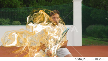 Swinging athlete in white using racket hitting ball on red tennis court, with golden particles Swinging athlete in white using racket hitting ball on red tennis court, with golden particles 135403500