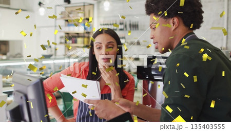 Reviewing printed report cafe staff wearing aprons at counter with espresso maker and gold confetti 135403555