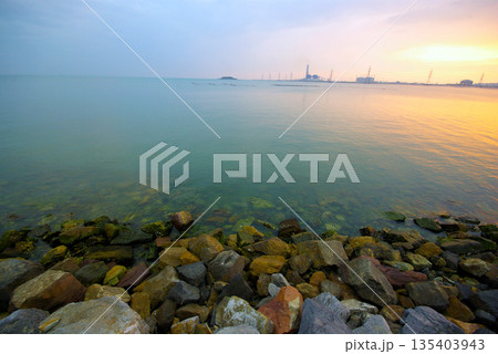 Soft waves on a rocky beach in the evening Soft waves on a rocky beach in the evening 135403943
