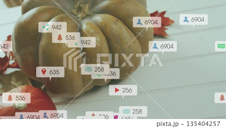Social media interaction icons image over autumn pumpkins and leaves on white surface Social media interaction icons image over autumn pumpkins and leaves on white surface 135404257