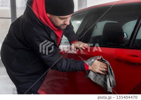 Man rags his red car after washing crop photo close up 135404470