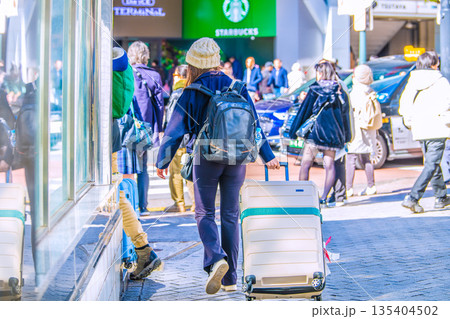 日本の東京都市景観スーツケース。インバウンド続く…渋谷スクランブル交差点脇・外国人観光客のカップル… 日本の東京都市景観スーツケース。インバウンド続く…渋谷スクランブル交差点脇・外国人観光客のカップル… 135404502