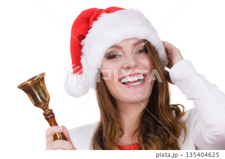 Woman in santa claus hat ringing a bell Woman in santa claus hat ringing a bell 135404625