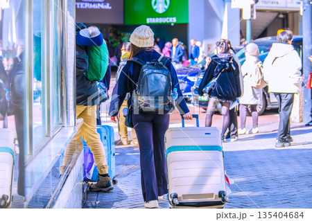 日本の東京都市景観スーツケース。インバウンド続く…渋谷スクランブル交差点脇・外国人観光客のカップル… 135404684