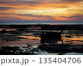 Silhouette long tail boat parking on the beach in the morning with sunrise sky and horizontal line in background 135404706