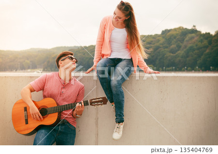 Happy couple with guitar outdoor 135404769