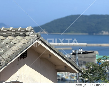 港町を見下ろす日本家屋の瓦屋根と夏の海 港町を見下ろす日本家屋の瓦屋根と夏の海 135405340