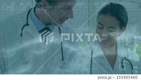 Reviewing patient data, doctors in white coats and stethoscopes in hallway, with digital overlay 135405460