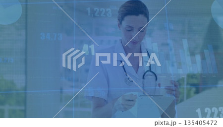 Nurse in uniform recording patient data in corridor, with stethoscope clipboard pen digital charts Nurse in uniform recording patient data in corridor, with stethoscope clipboard pen digital charts 135405472