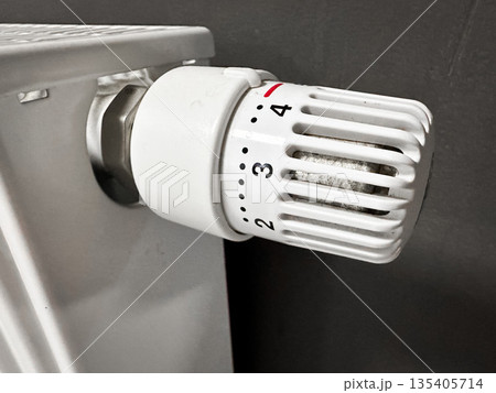 Close-up of a white radiator thermostat in a home setting. 135405714