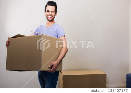 Mid adult man standing holding large open-top cardboard box near sealed box in empty room Mid adult man standing holding large open-top cardboard box near sealed box in empty room 135407177
