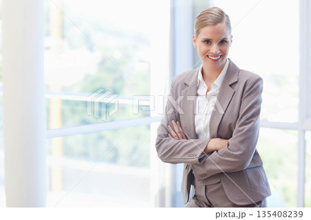 Female executive standing by glass windows with metal balcony railing in office lobby, copy space Female executive standing by glass windows with metal balcony railing in office lobby, copy space 135408239
