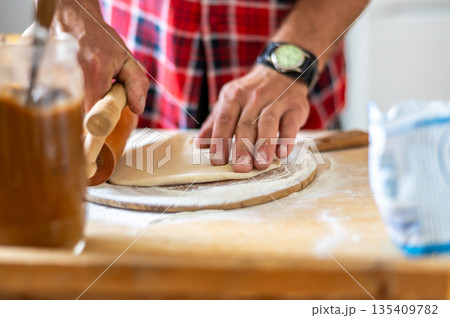 Detail of hands of men rolling the dough. Preparation for baking of traditional czech pastry. Homemade fresh food Detail of hands of men rolling the dough. Preparation for baking of traditional czech pastry. Homemade fresh food 135409782