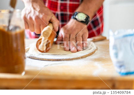 Detail of hands of men rolling the dough. Preparation for baking of traditional czech pastry. Homemade fresh food 135409784