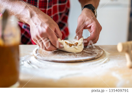Detail of hands of men rolling the dough. Preparation for baking of traditional czech pastry. Homemade fresh food Detail of hands of men rolling the dough. Preparation for baking of traditional czech pastry. Homemade fresh food 135409791