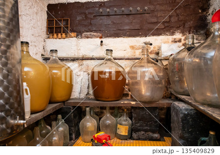 View of old fashioned wine cellar with glass storage for wine during fermentation process. 135409829