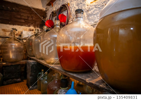 View of old fashioned wine cellar with glass storage for wine during fermentation process. 135409831