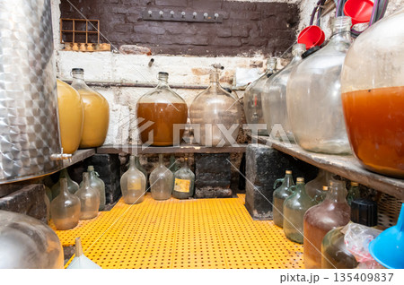 View of old fashioned wine cellar with glass storage for wine during fermentation process. 135409837