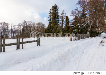 Meadow covered by snow in winter. Old wooden fence. Trees near. Meadow covered by snow in winter. Old wooden fence. Trees near. 135409896
