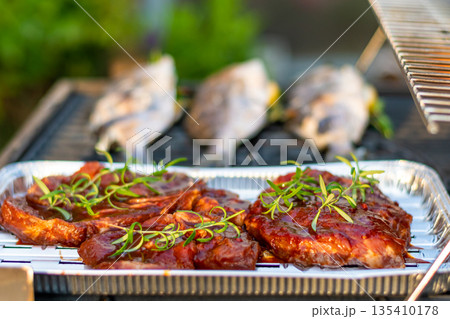 Sea bream dorado fish placed on the grill. Fresh sea food with herb and lemon. Summer bbq 135410178