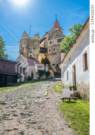 Outdoor view of Pernstejn castle near the Nedvedice village, Czech Republic. Fairytale castle on hill during summer day. Big stone walls and towers. 135410235