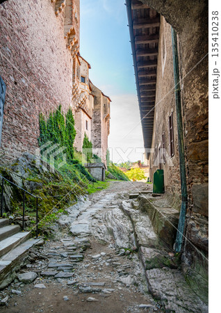 Outdoor view of Pernstejn castle near the Nedvedice village, Czech Republic. Fairytale castle on hill during summer day. Big stone walls and towers. 135410238