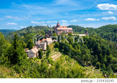 Outdoor view of Pernstejn castle near the Nedvedice village, Czech Republic. Fairytale castle on hill during summer day. Big stone walls and towers. 135410245