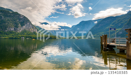 Hallstatt see lake near the Salzburg city. View of lake and big mountains in background. Cloudy weather, big clouds and mist over lake. 135410385
