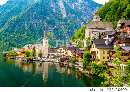 Famous view of Hallstatt city and church near the lake. Mountains in the background. Summer rainy day, soft colors, cloudy weather. Famous view of Hallstatt city and church near the lake. Mountains in the background. Summer rainy day, soft colors, cloudy weather. 135410400