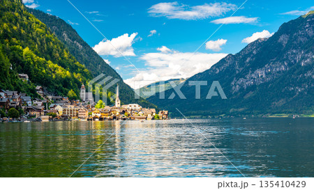 Famous Hallstatt city panorama with typical church near the Hallstatter see. Dramatic clouds on the sky. Famous tourist destination in Austria. 135410429