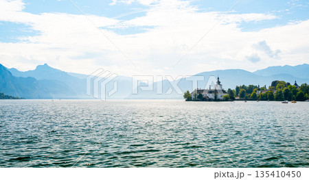 Schloss Ort castle near Traunsee, Austria. View of ancient castle with long bridge over lake. Famous tourist destination. Schloss Ort castle near Traunsee, Austria. View of ancient castle with long bridge over lake. Famous tourist destination. 135410450