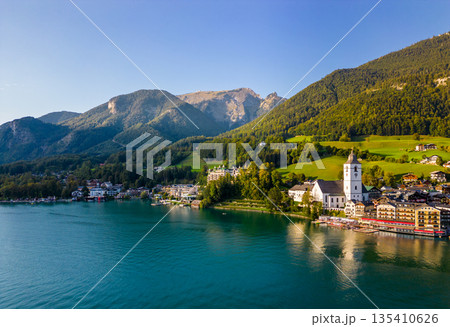 Beautiful aerial view of the popular village of Sankt Wolfgang im Salzkammergut. Alpine mountains, church and Wolfgangsee. Upper Austria, Salzburg. 135410626