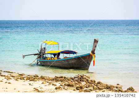 Long tailed boats near tropical beach at Ko Phi Phi, Thailand. Tropic beach with white sand and turquoise water, concept of vacation in paradise. 135410742