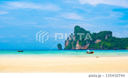Landscape view of coastline with limestone rock and boats on ocean at Ko Phi Phi islands, Thailand. Concept of exotic tropical vacation and beautiful nature in paradise Landscape view of coastline with limestone rock and boats on ocean at Ko Phi Phi islands, Thailand. Concept of exotic tropical vacation and beautiful nature in paradise 135410744