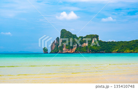 Landscape view of coastline with limestone rock and boats on ocean at Ko Phi Phi islands, Thailand. Concept of exotic tropical vacation and beautiful nature in paradise 135410748