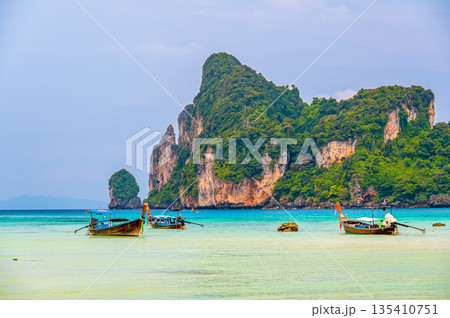 Landscape view of coastline with limestone rock and boats on ocean at Ko Phi Phi islands, Thailand. Concept of exotic tropical vacation and beautiful nature in paradise Landscape view of coastline with limestone rock and boats on ocean at Ko Phi Phi islands, Thailand. Concept of exotic tropical vacation and beautiful nature in paradise 135410751