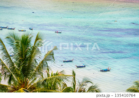 Long tail boats are parking at Tonsai pier, Ko Phi Phi islands, Thailand. Summer weather, concept of tropical vacation in paradise. Long tail boats are parking at Tonsai pier, Ko Phi Phi islands, Thailand. Summer weather, concept of tropical vacation in paradise. 135410764