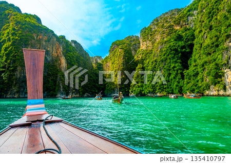 View of Pi Leh lagoon (also known as Green Lagoon) at Ko Phi Phi islands, Thailand. View from typical long tailed boat. Typical Thai picture of tropical paradise. Limestone rock and turquoise water. View of Pi Leh lagoon (also known as Green Lagoon) at Ko Phi Phi islands, Thailand. View from typical long tailed boat. Typical Thai picture of tropical paradise. Limestone rock and turquoise water. 135410797