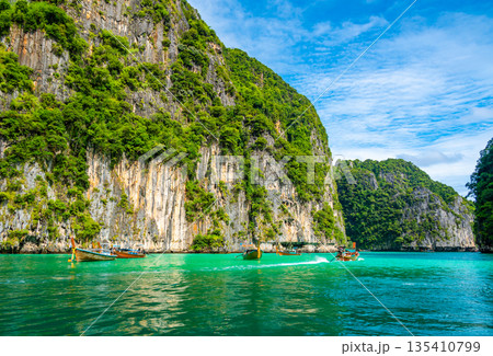 View of Pi Leh lagoon (also known as Green Lagoon) at Ko Phi Phi islands, Thailand. View from typical long tailed boat. Typical Thai picture of tropical paradise. Limestone rock and turquoise water. View of Pi Leh lagoon (also known as Green Lagoon) at Ko Phi Phi islands, Thailand. View from typical long tailed boat. Typical Thai picture of tropical paradise. Limestone rock and turquoise water. 135410799
