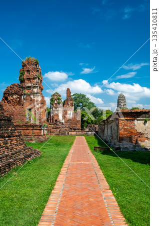 Ruins of ancient city and temples Ayutthaya, Thailand. Old kingdom of Siam. Summer day with blue sky. Famous tourist destination, spiritual place near Bangkok. Ruins of ancient city and temples Ayutthaya, Thailand. Old kingdom of Siam. Summer day with blue sky. Famous tourist destination, spiritual place near Bangkok. 135410811