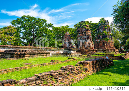 Ruins of ancient city and temples Ayutthaya, Thailand. Old kingdom of Siam. Summer day with blue sky. Famous tourist destination, spiritual place near Bangkok. Ruins of ancient city and temples Ayutthaya, Thailand. Old kingdom of Siam. Summer day with blue sky. Famous tourist destination, spiritual place near Bangkok. 135410813