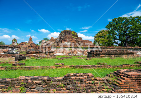 Ruins of ancient city and temples Ayutthaya, Thailand. Old kingdom of Siam. Summer day with blue sky. Famous tourist destination, spiritual place near Bangkok. 135410814