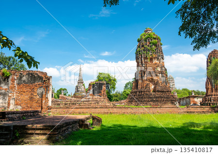 Ruins of ancient city and temples Ayutthaya, Thailand. Old kingdom of Siam. Summer day with blue sky. Famous tourist destination, spiritual place near Bangkok. Ruins of ancient city and temples Ayutthaya, Thailand. Old kingdom of Siam. Summer day with blue sky. Famous tourist destination, spiritual place near Bangkok. 135410817