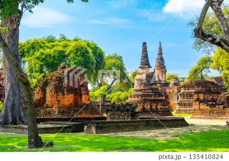 Ruins of ancient city and temples Ayutthaya, Thailand. Old kingdom of Siam. Summer day with blue sky. Famous tourist destination, spiritual place near Bangkok. Ruins of ancient city and temples Ayutthaya, Thailand. Old kingdom of Siam. Summer day with blue sky. Famous tourist destination, spiritual place near Bangkok. 135410824