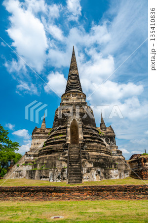 Ruins of ancient city and temples Ayutthaya, Thailand. Old kingdom of Siam. Summer day with blue sky. Famous tourist destination, spiritual place near Bangkok. 135410836