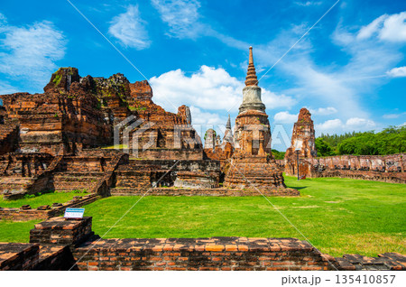 Ruins of ancient city and temples Ayutthaya, Thailand. Old kingdom of Siam. Summer day with blue sky. Famous tourist destination, spiritual place near Bangkok. Ruins of ancient city and temples Ayutthaya, Thailand. Old kingdom of Siam. Summer day with blue sky. Famous tourist destination, spiritual place near Bangkok. 135410857