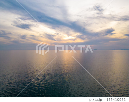 Sunset over the ocean, soft warm colors. Aerial view above ocean. 135410931