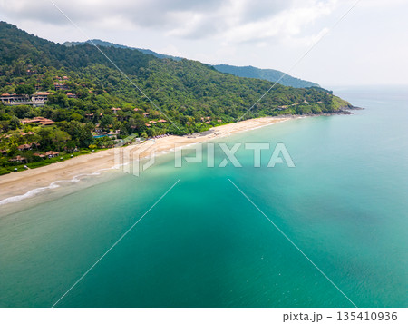 Aerial drone view of bamboo bay and beach at Koh Lanta island, Thailand. Tropical forest near the rocky beach and white sand with turquoise water. 135410936